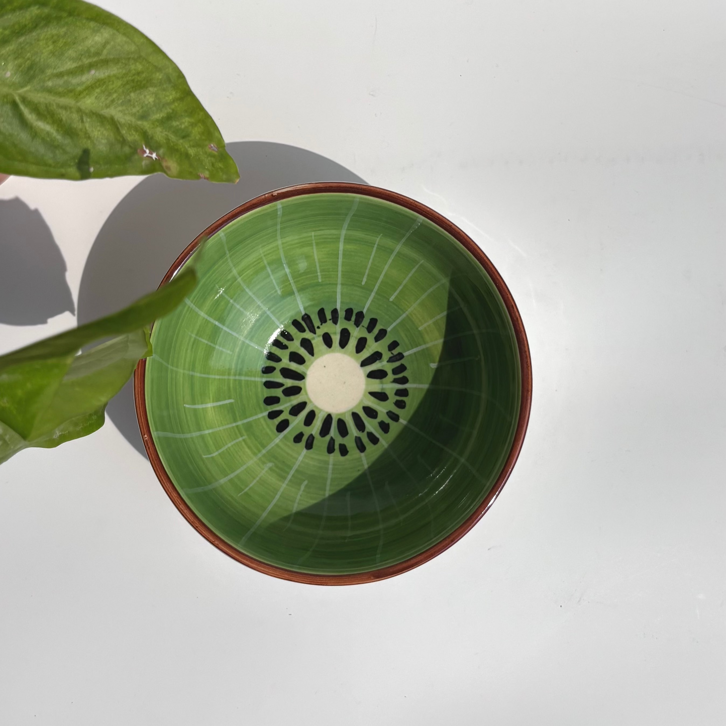 Green ceramic bowl with brown rim on a white background