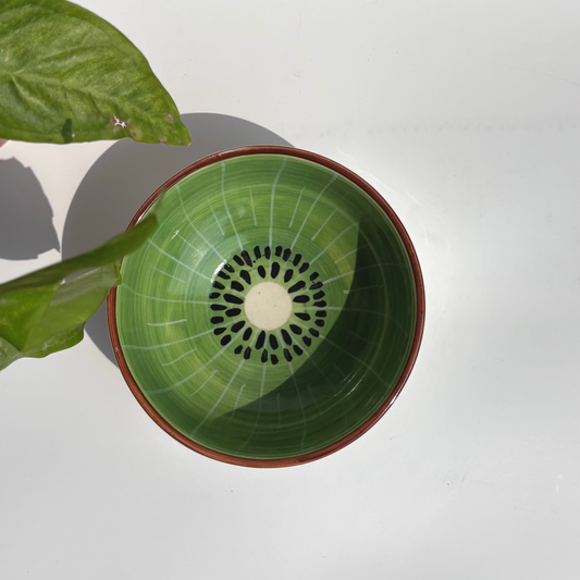 Green ceramic bowl with brown rim on a white background