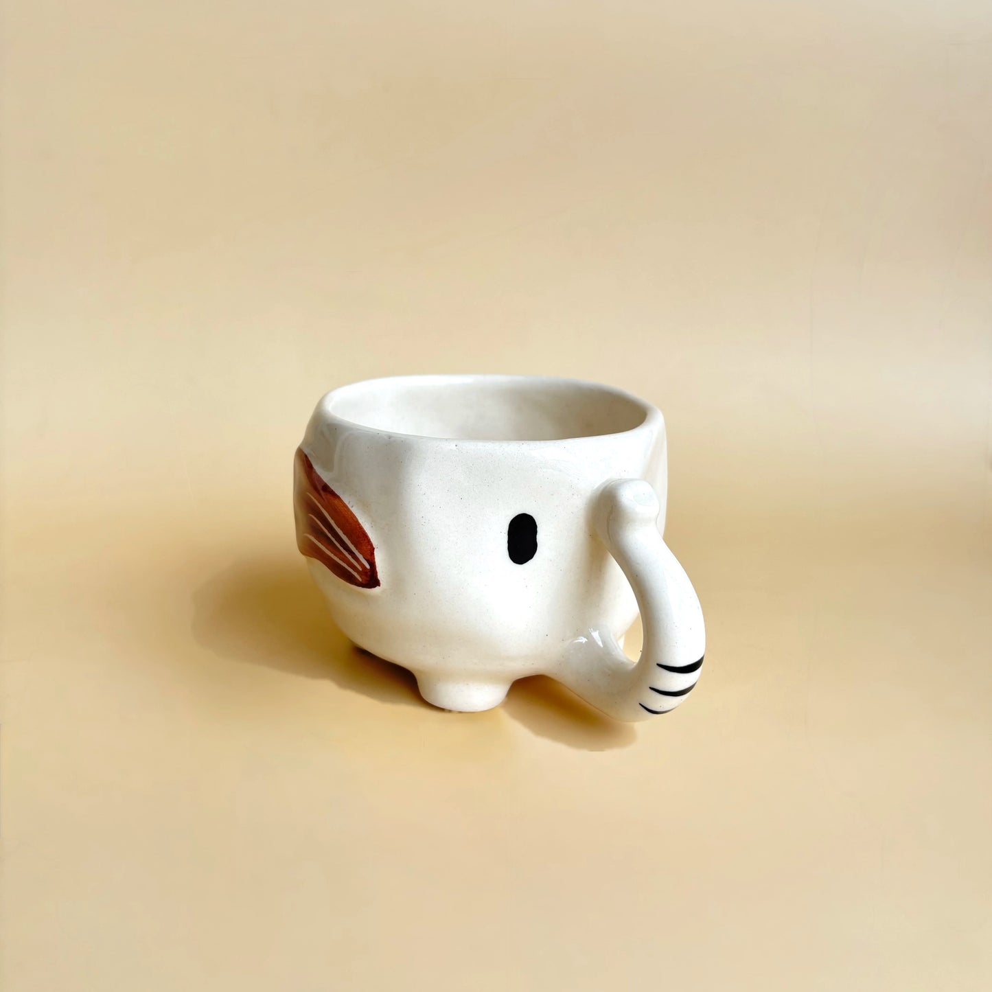 Ceramic mug shaped like a rabbit on a beige background