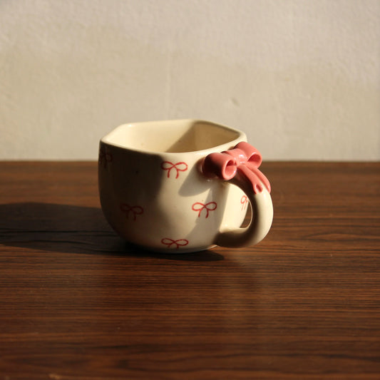 Ceramic cup with decorative handle on a wooden surface