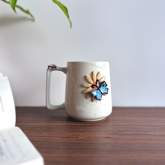 White ceramic mug with butterfly design on a wooden surface