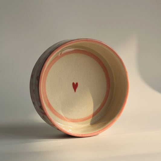 Ceramic bowl with a red heart on a neutral background