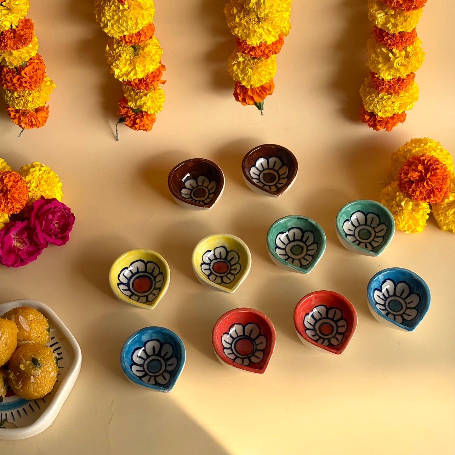 Decorative flower garlands and colorful clay pots on a beige background