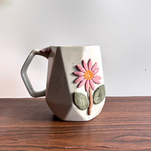 Ceramic mug with a floral design on a wooden surface