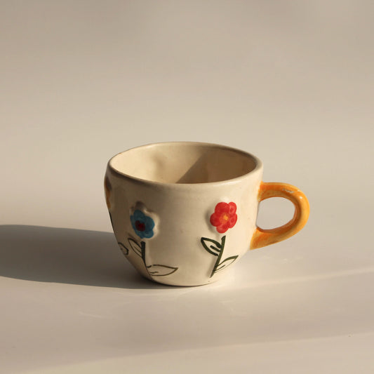Ceramic mug with floral designs on a plain background