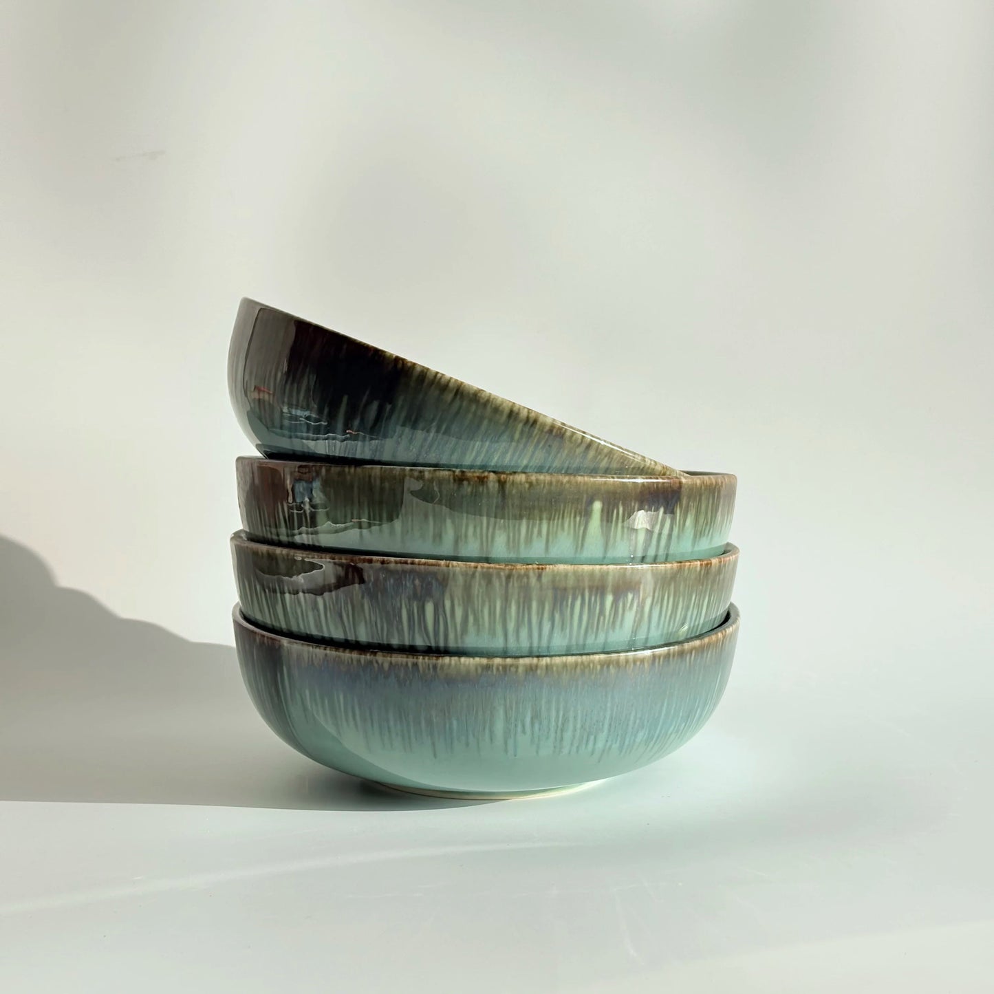 Stack of ceramic bowls with a textured finish on a light background