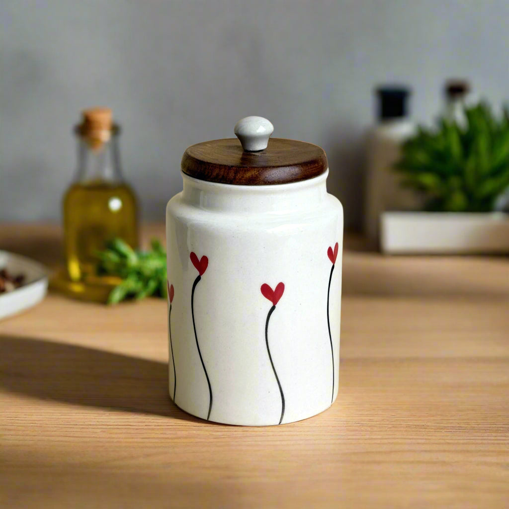 Ceramic jar with wooden lid and red heart designs on a beige background