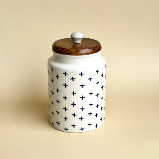 Ceramic jar with a wooden lid on a beige background