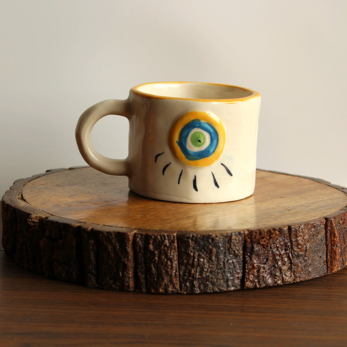 Ceramic mug with decorative design on a wooden coaster