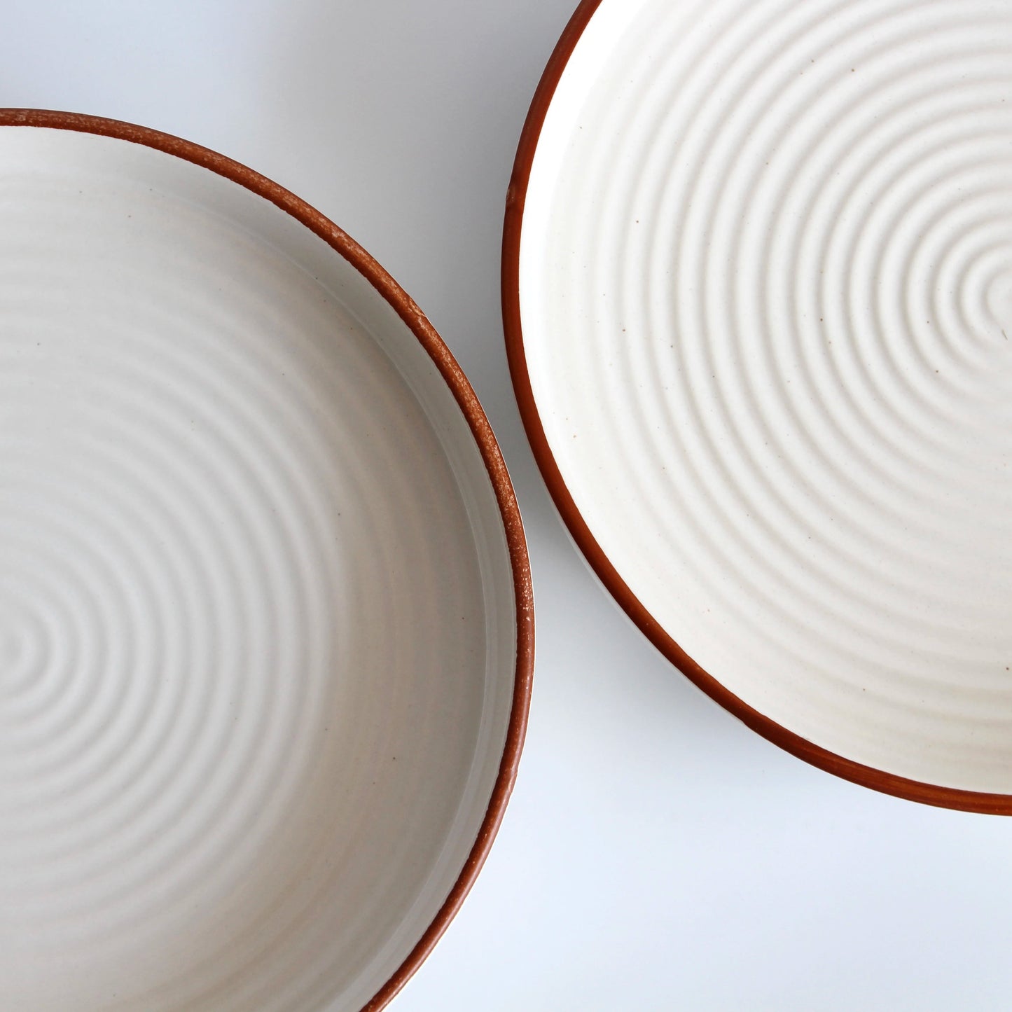 Two ceramic plates with concentric circle patterns on a white background