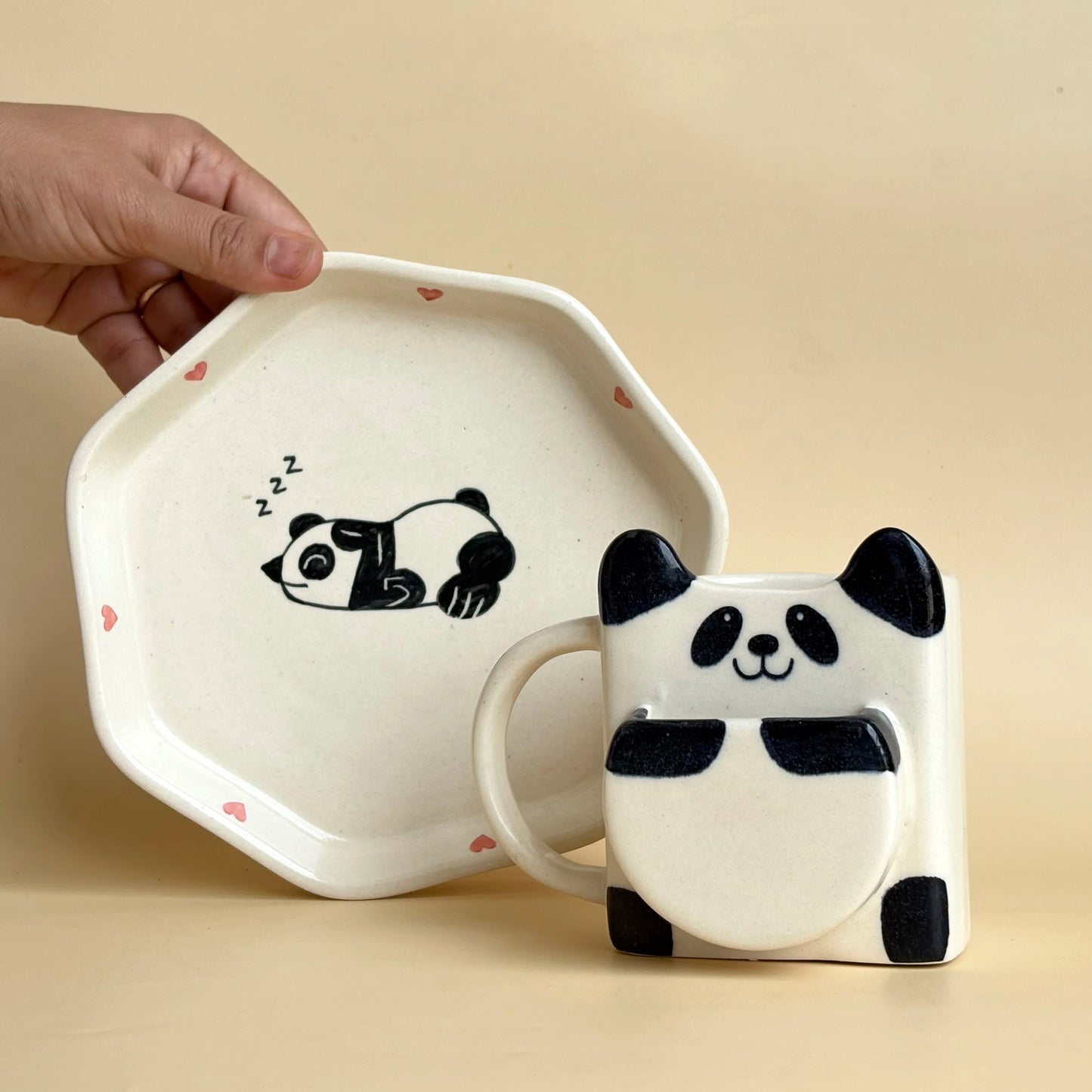 Panda-themed mug and plate set on a beige background