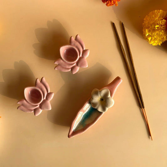 Decorative ceramic items with floral designs on a beige surface with yellow flowers in the background.