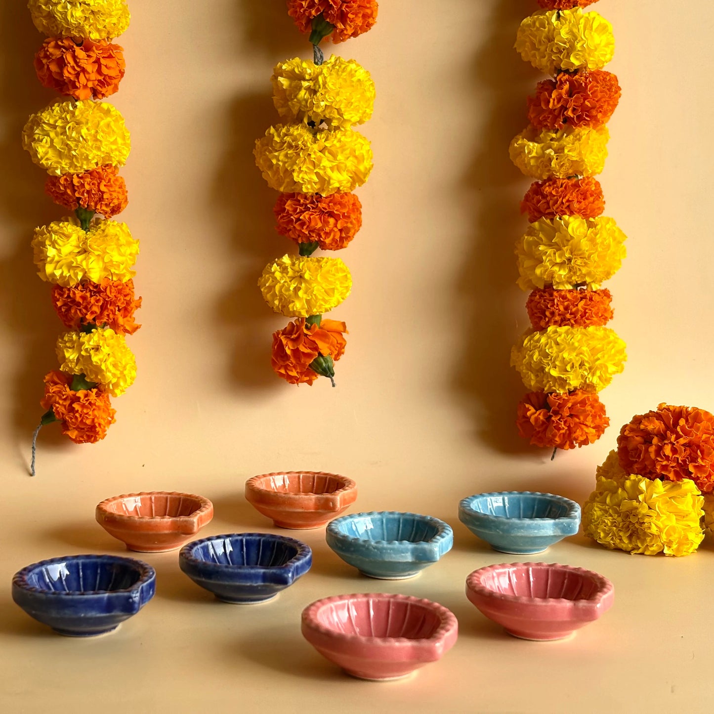 Decorative flower garlands and colorful bowls on a beige background