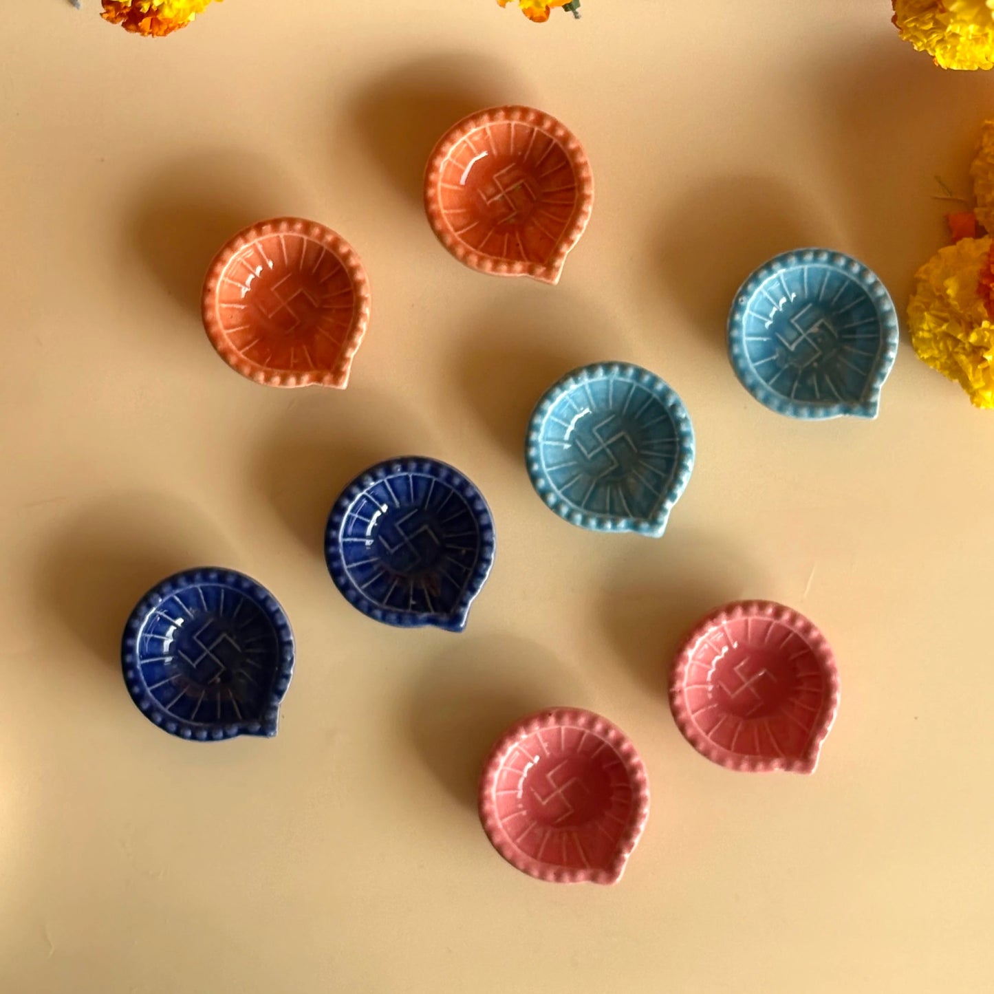 Colorful chocolate cups on a beige surface with yellow flowers in the background