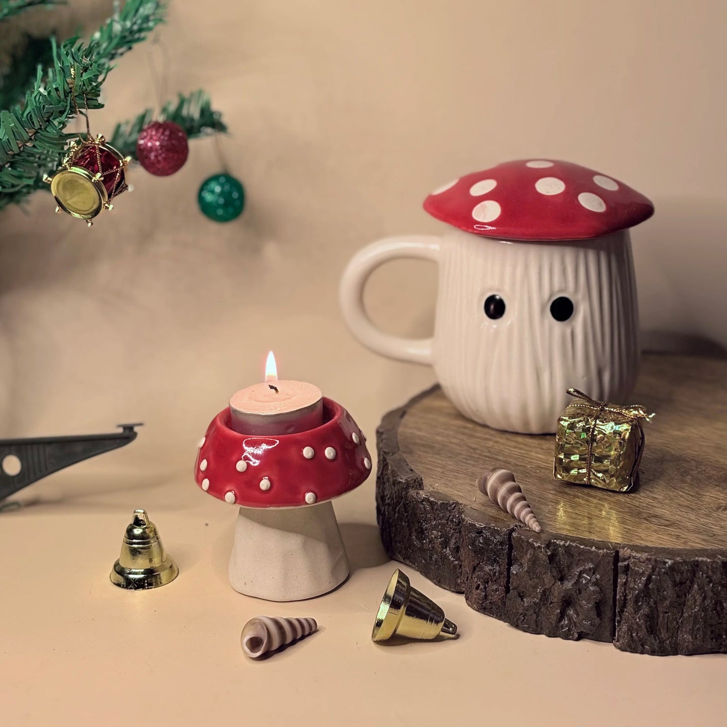 Mushroom-shaped candle and mug with Christmas decorations on a wooden surface