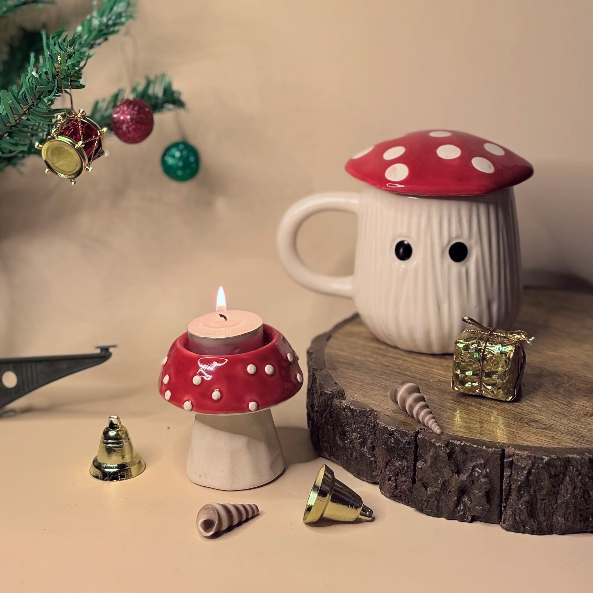 Mushroom-shaped candle and mug with Christmas decorations on a wooden surface