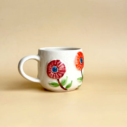 White mug with floral designs on a beige background