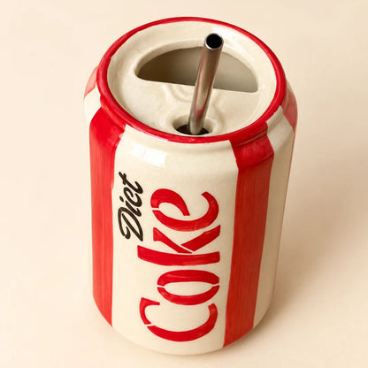 A ceramic can-shaped cup with a metal straw, featuring the red and white 'Diet Coke' logo on a warm cream background.