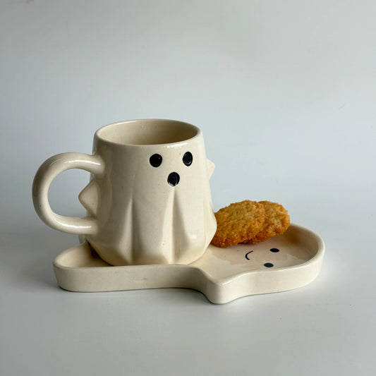 Ceramic ghost mug with matching tray and cookie on a light gray background