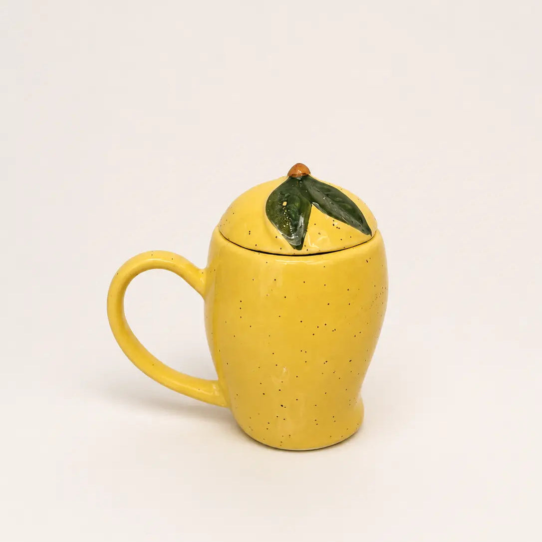 Yellow ceramic mug shaped like a mango with a green leaf on lid