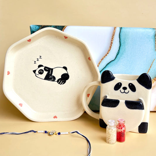 Ceramic mug and plate with panda design on a beige surface