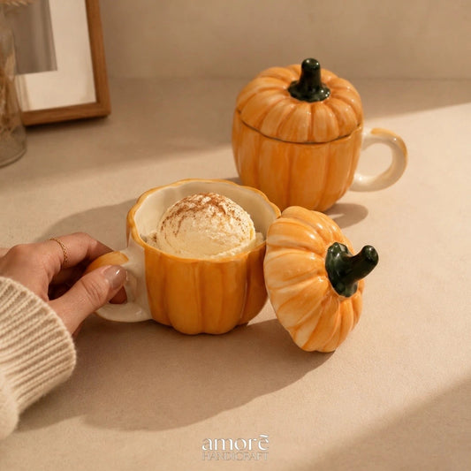 Pumpkin-shaped mugs with a hand holding one, on a neutral background.