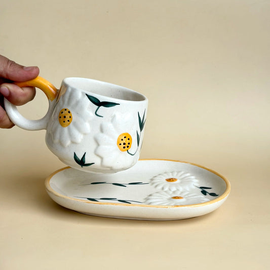 Ceramic mug and saucer with floral design on a beige background